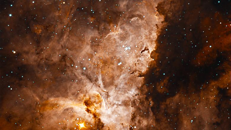 An image of a reddish nebula cloud surrounded by stars